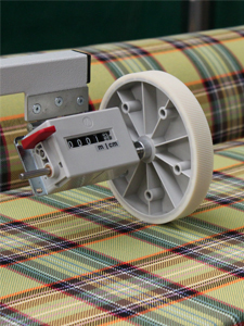 MiniScience measuring wheel mounted over fabric on a production line